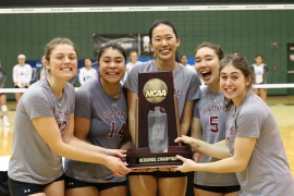 portrait of five volleyball players holding trophy